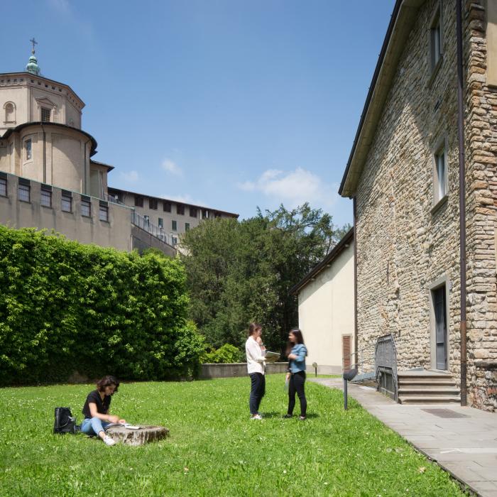UniBg sede di Salvecchio, dove alcune studentesse studiano sedute sul prato